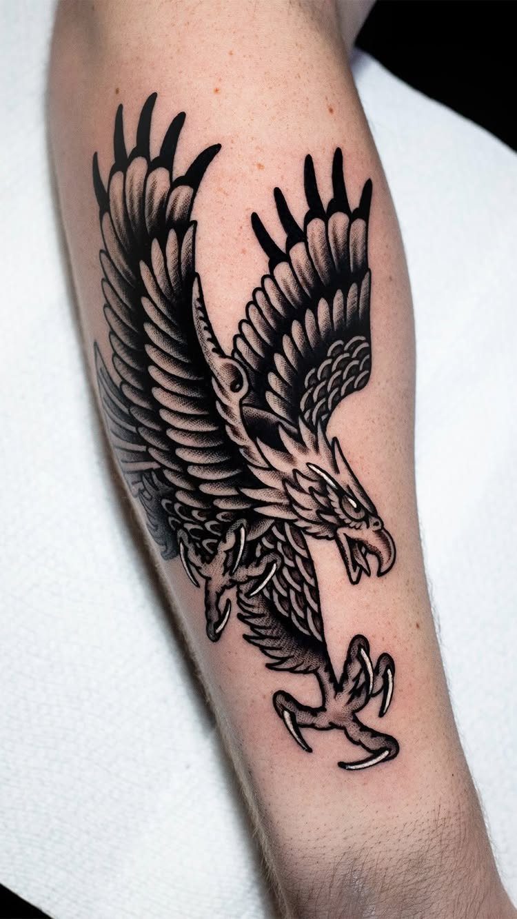 Eagle tattoo with bold black outlines and shading on a person's forearm