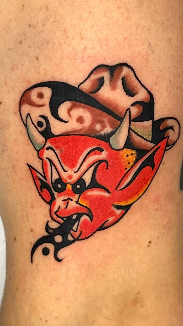 Red devil head tattoo wearing a brown cowboy hat in traditional style