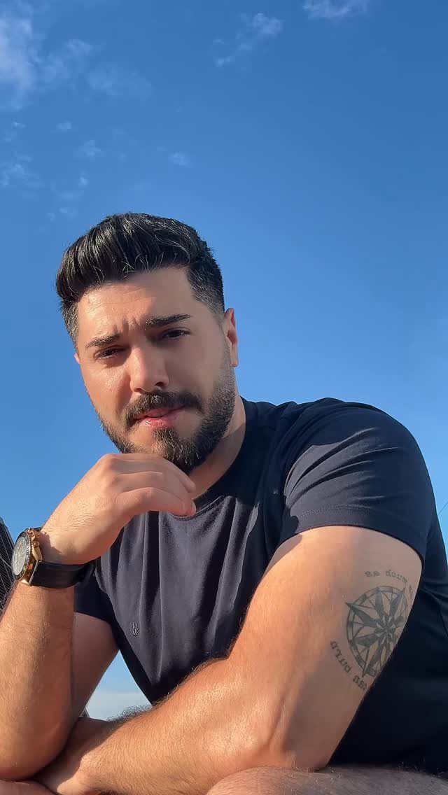 Man with a beard and a compass tattoo on his upper left arm.