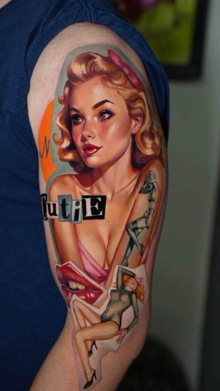 Pin-up girl tattoo on a man's arm with red lips and stylized text.