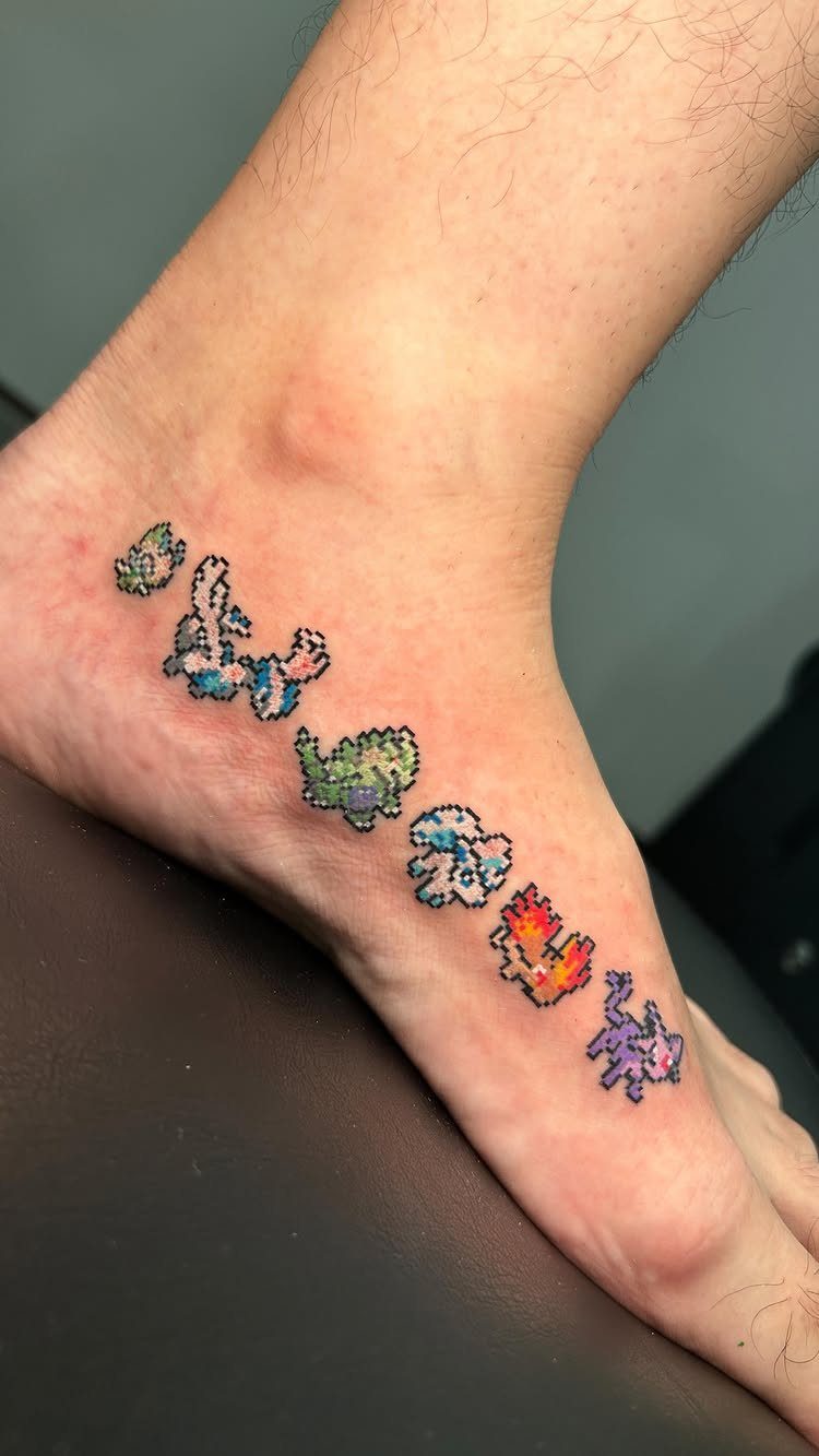 Pixel art Pokemon tattoos arranged in a row on a person's foot.
