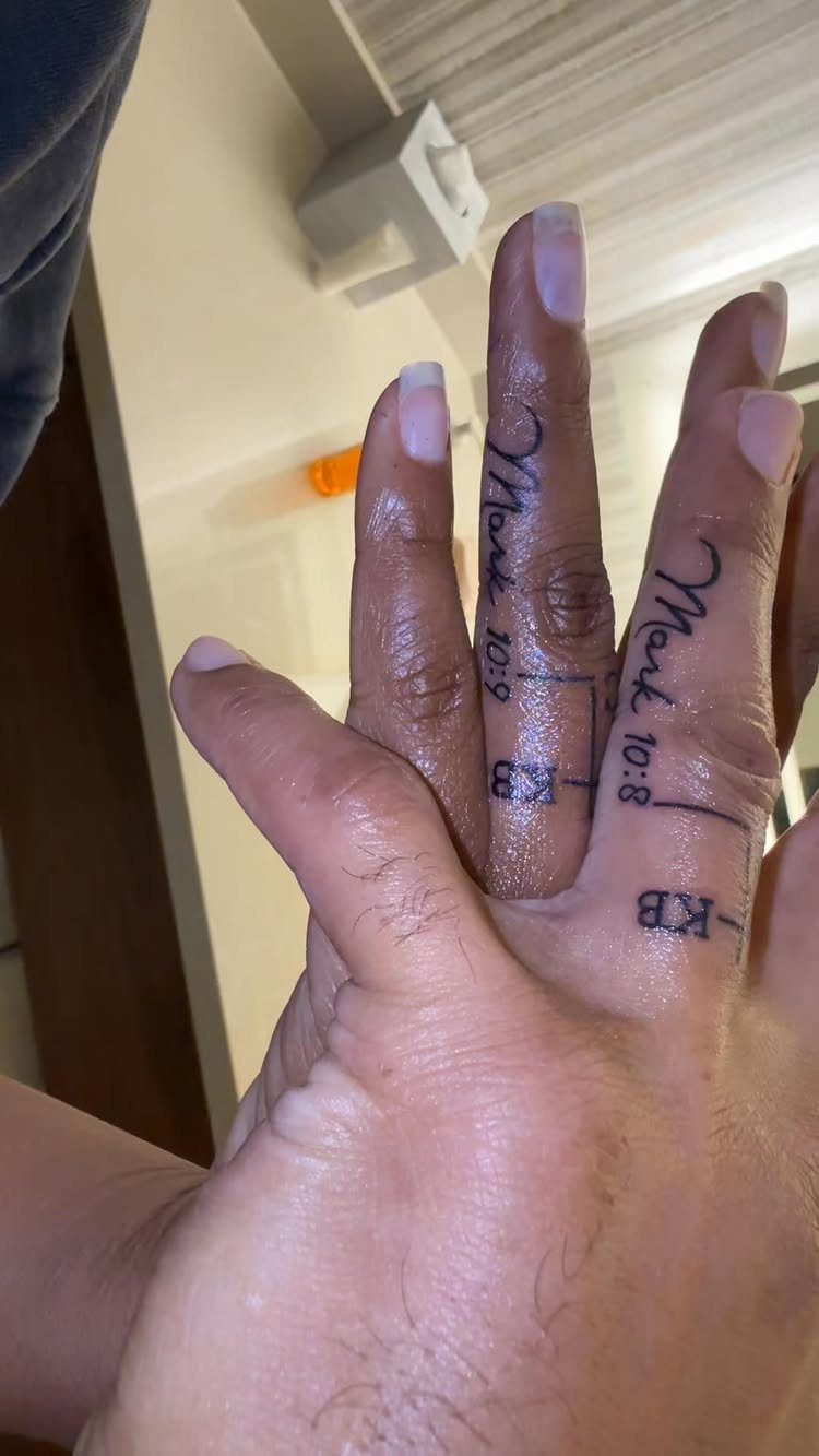 Tattooed ring fingers of two people featuring biblical verses and initials KB.